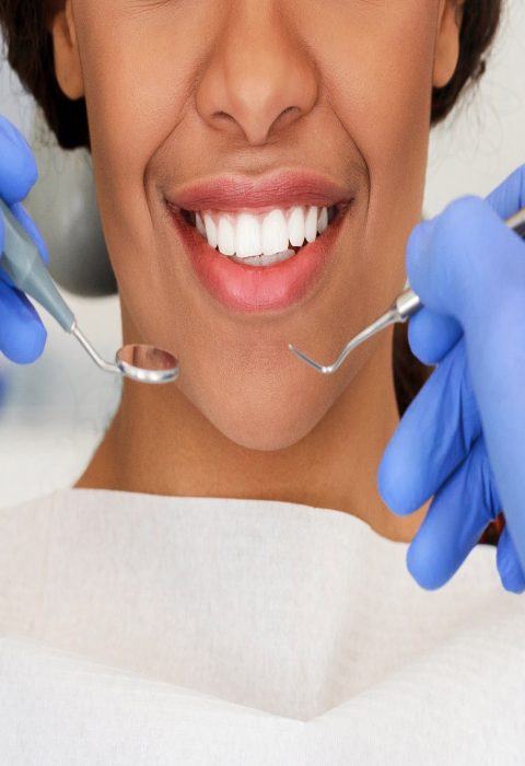 Beautiful african woman smile and dentist hands with dental tools, close up, panorama